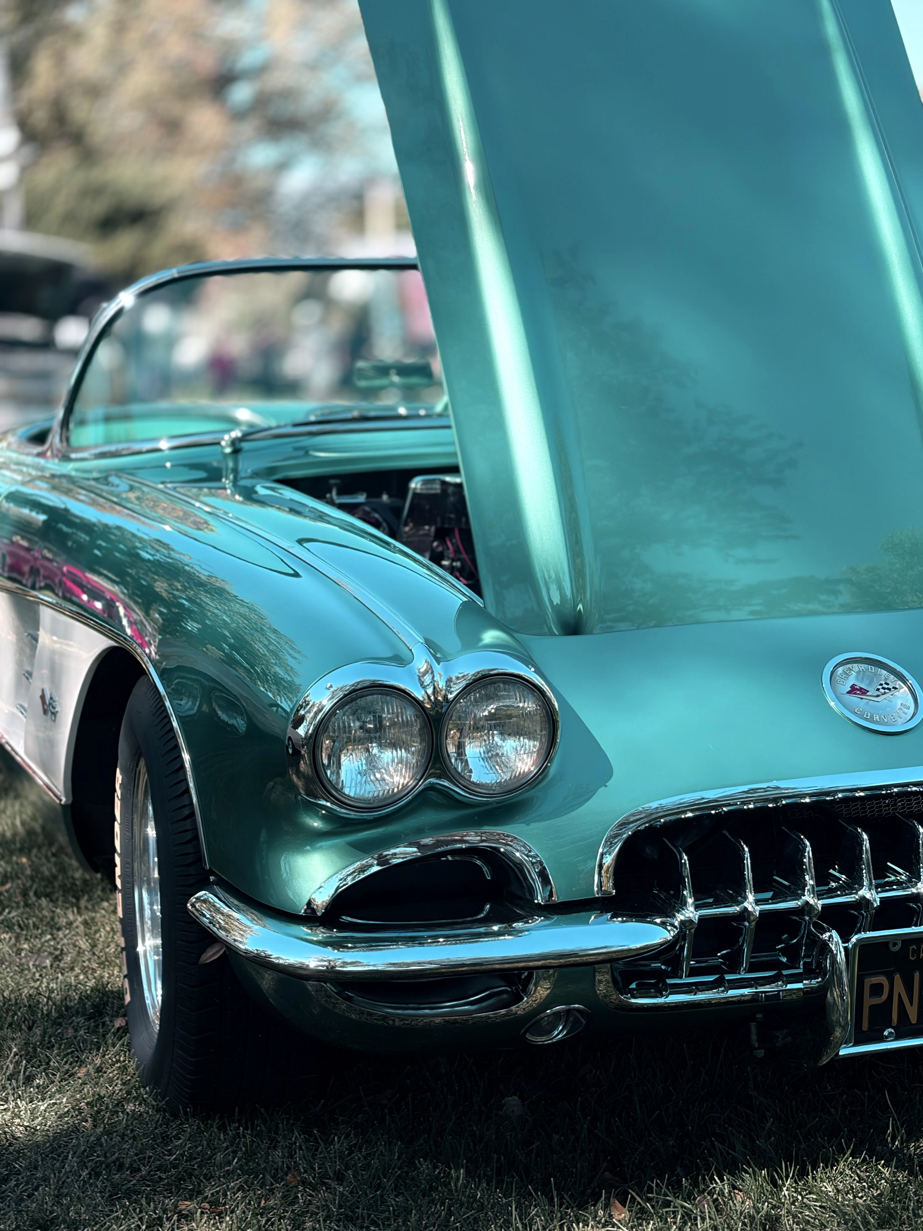 Turquoise classic Corvette with its hood raised