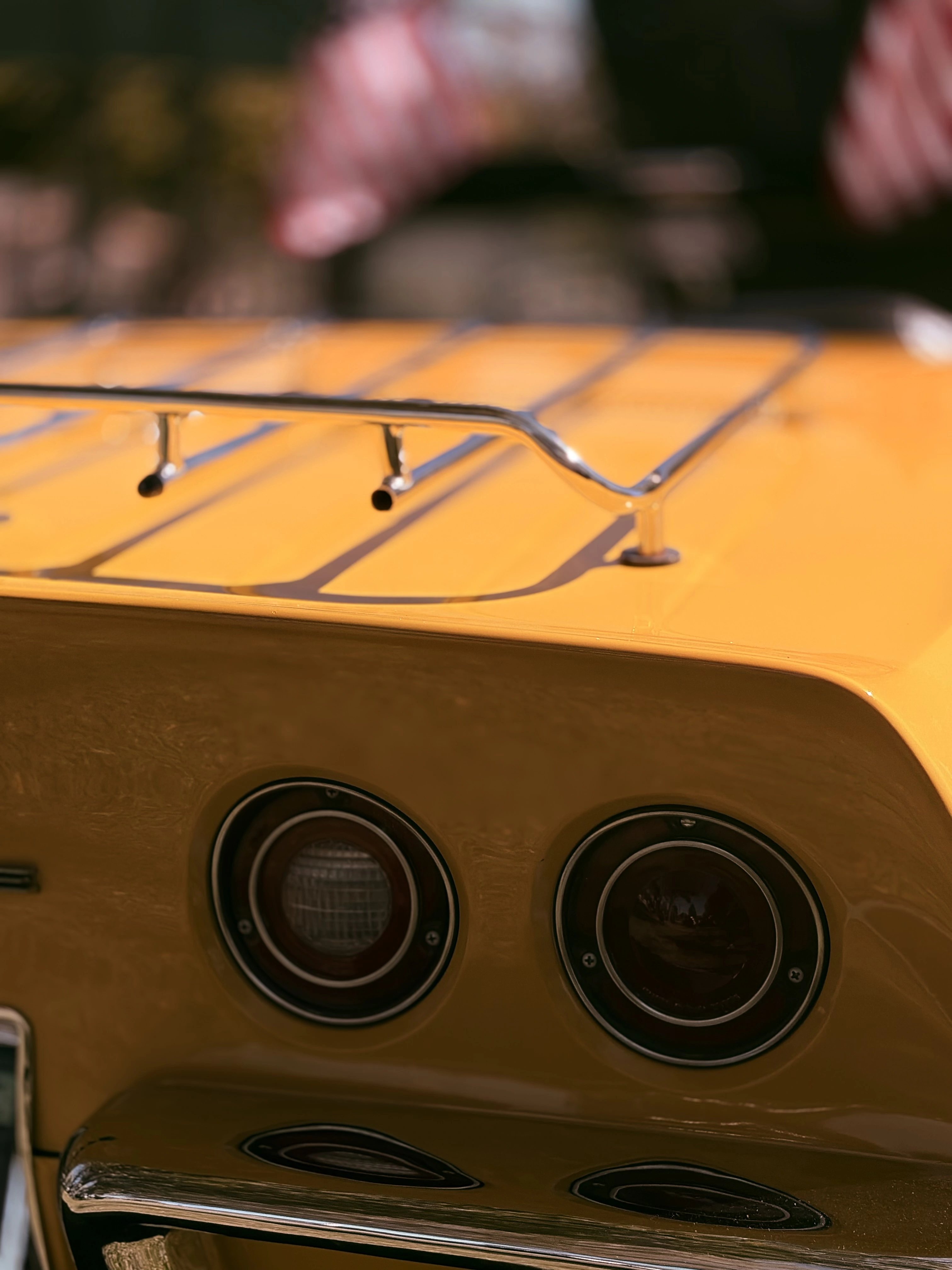 Round taillights and chrome luggage rack on a yellow classic Corvette