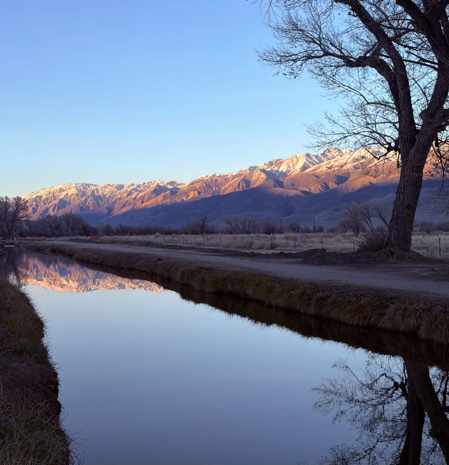 Evening mountains reflected in a calm canal