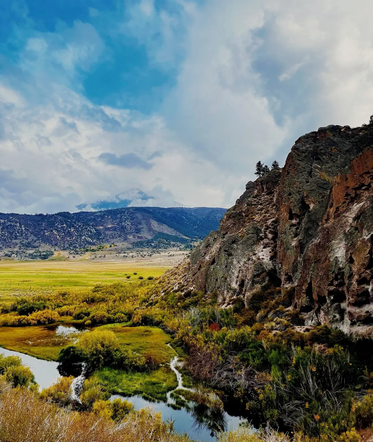 A green valley opening beneath volcanic cliffs