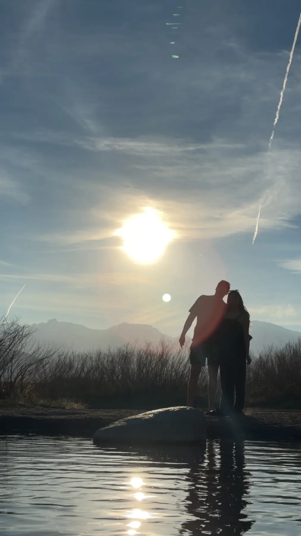 Two figures silhouetted in mountain sunlight