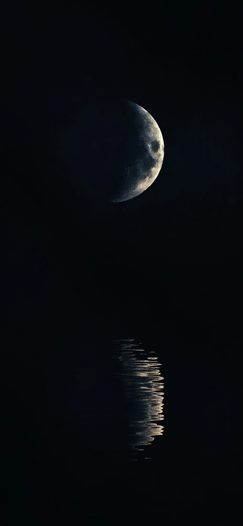 Crescent moon reflected on dark water