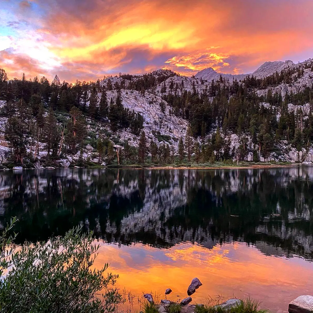 Alpine lake reflecting a fiery winter sunset