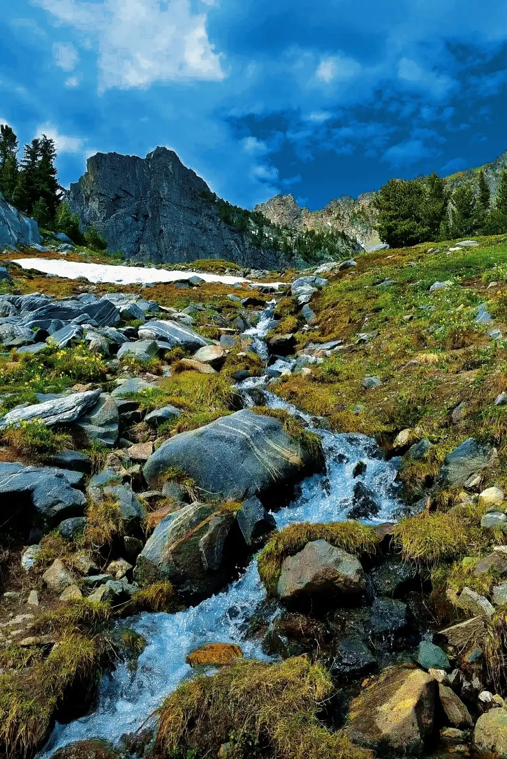 Rocky alpine stream below sharp mountain peaks