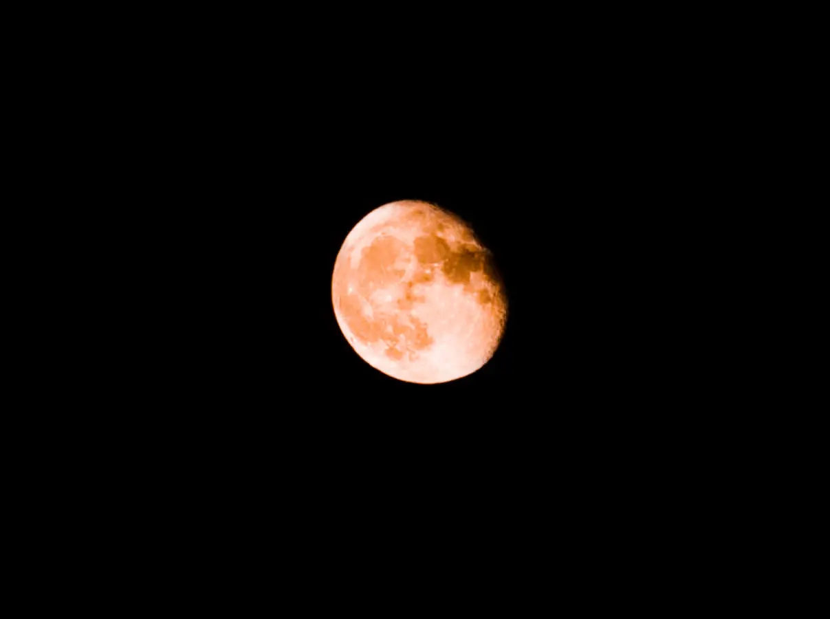 Copper-toned moon against a black sky