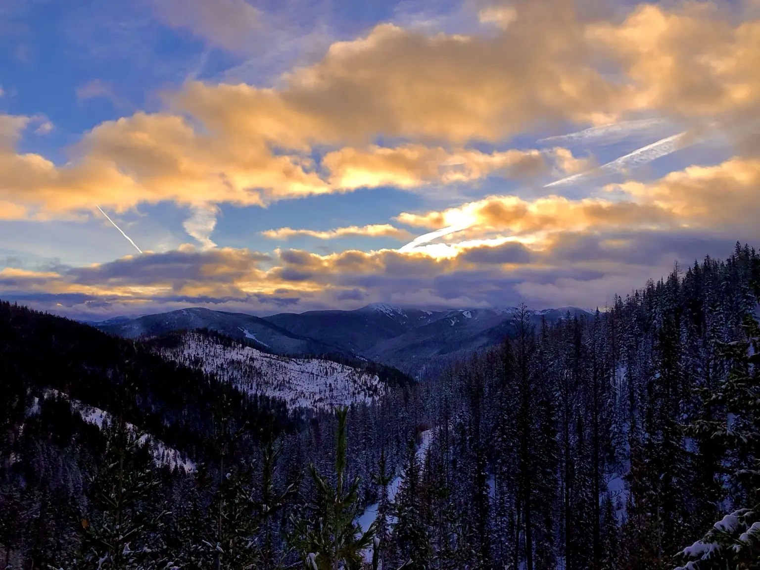 Snowy mountain cabin beneath dramatic clouds