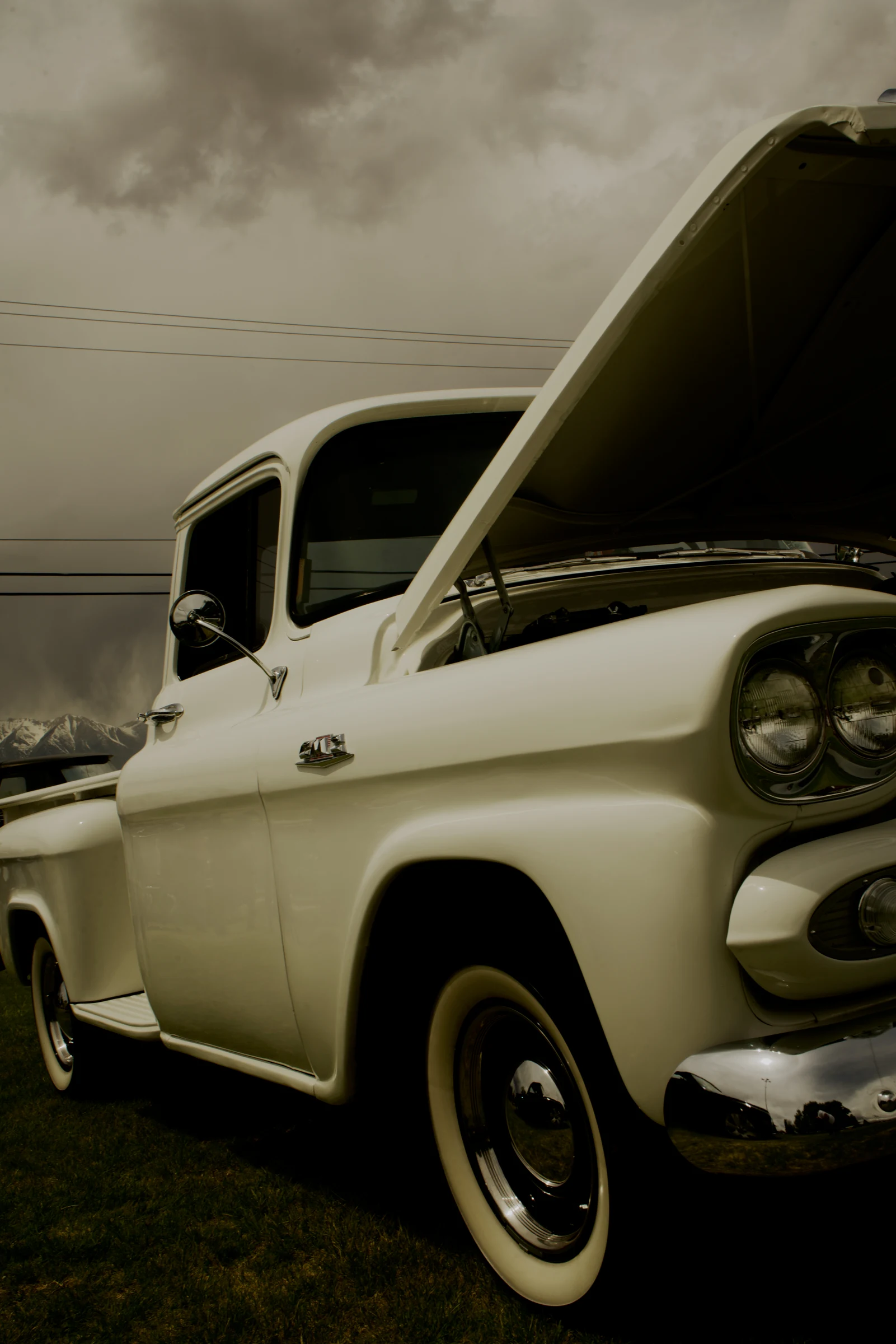 Cream-colored vintage pickup with its hood raised
