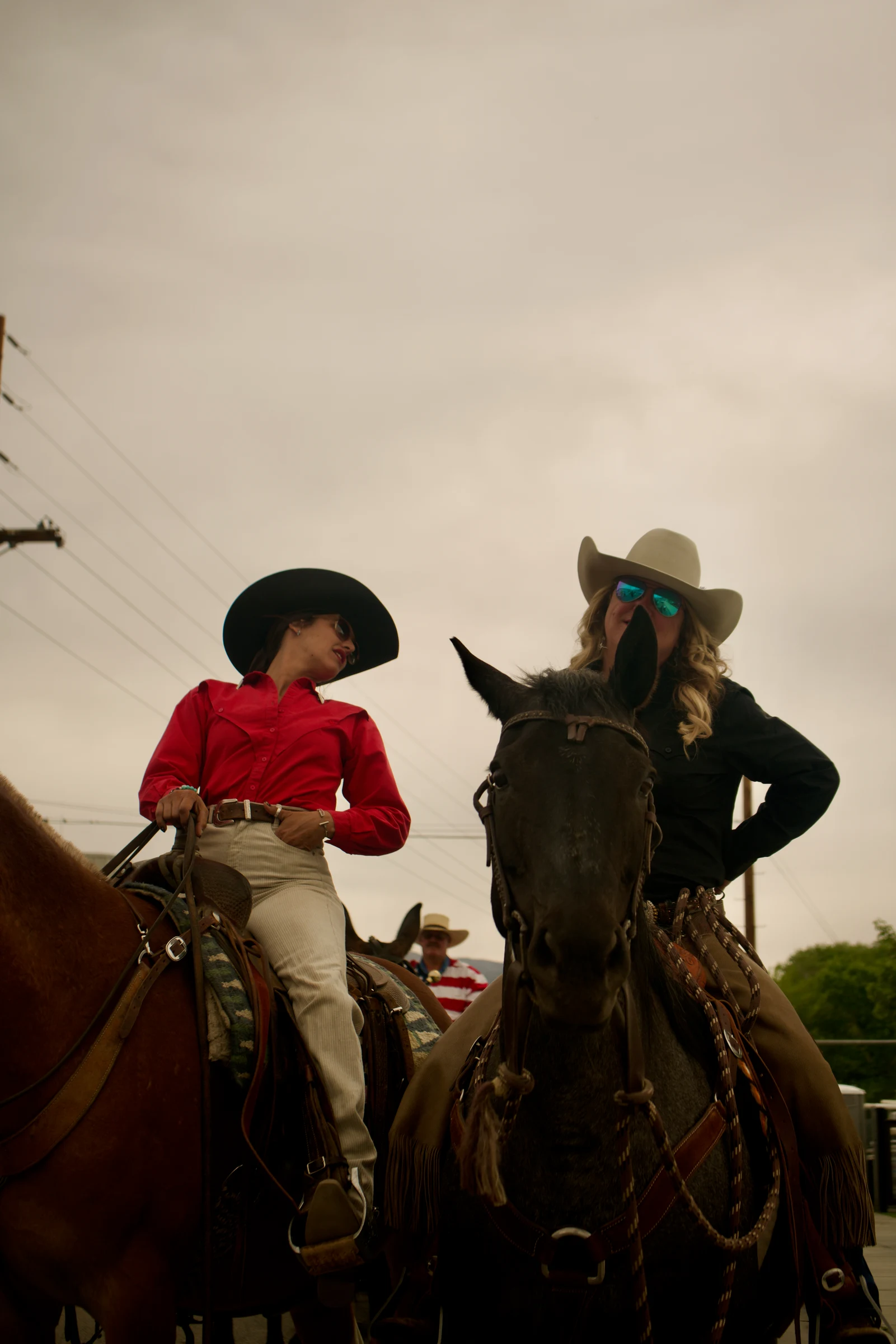 Two riders on horseback at a Western gathering