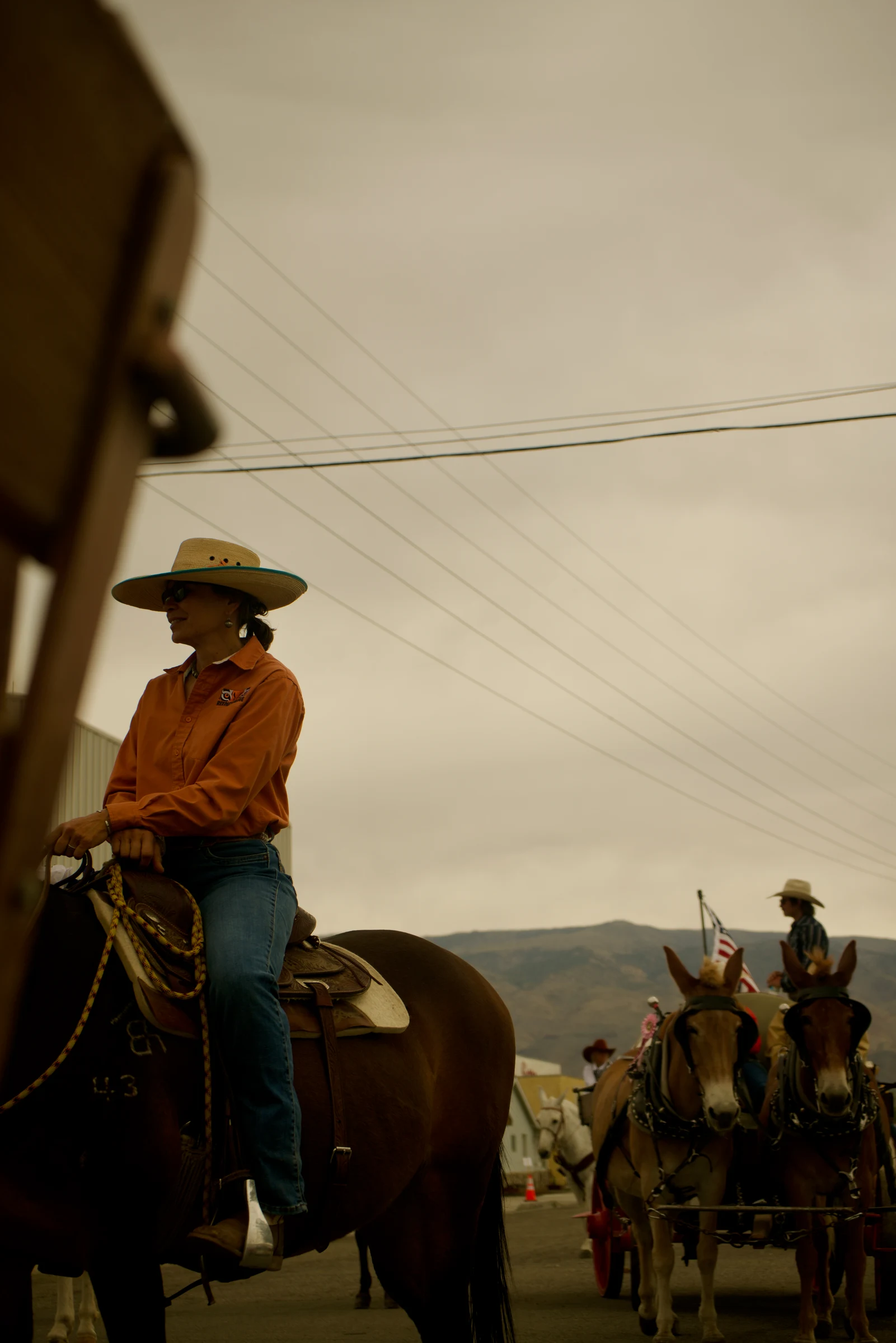 Cowboy on horseback beside a gathering of riders