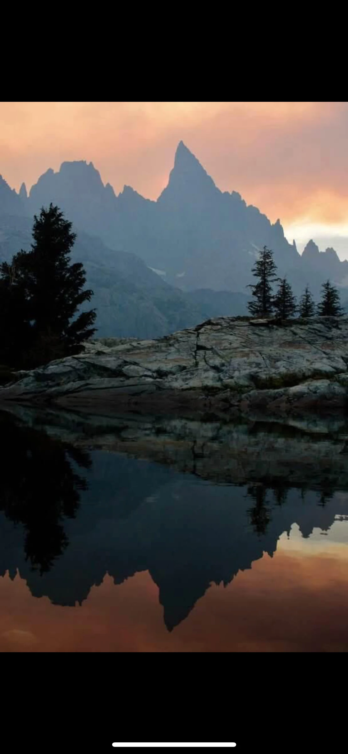 Mountain spires reflected in still water at dusk