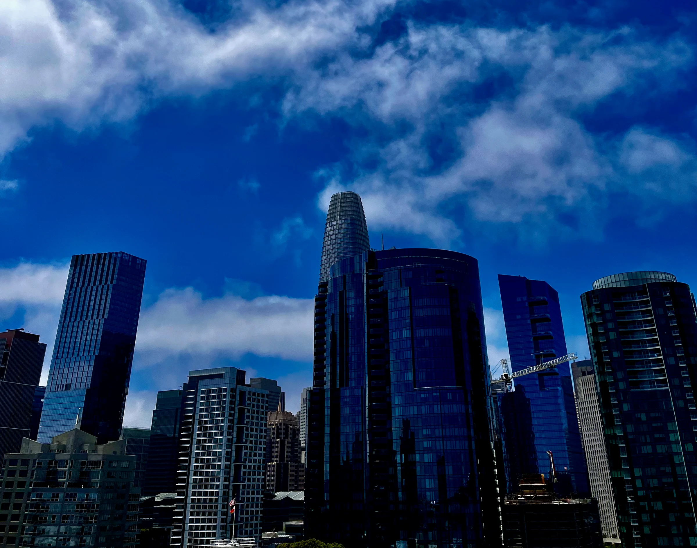 Downtown towers beneath bright clouds and blue sky